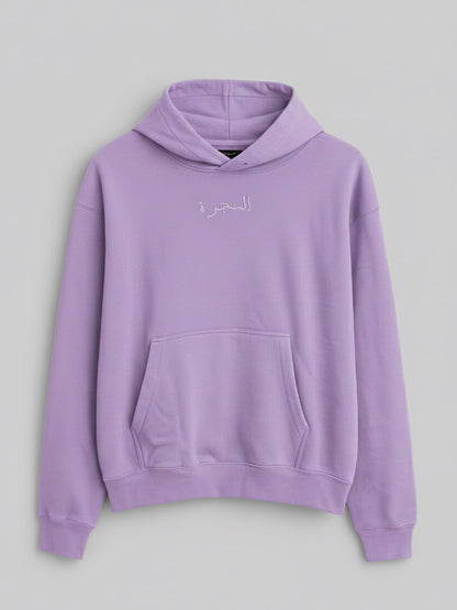 A lilac-colored hoodie with a kangaroo pocket and subtle embroidered Arabic text on the chest.