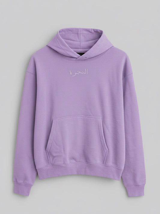 A lilac-colored hoodie with a kangaroo pocket and subtle embroidered Arabic text on the chest.